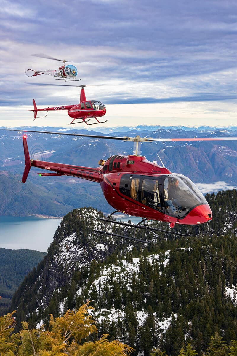 Flota de helicópteros de Chinook Helicopters volando en formación sobre las montañas de BC