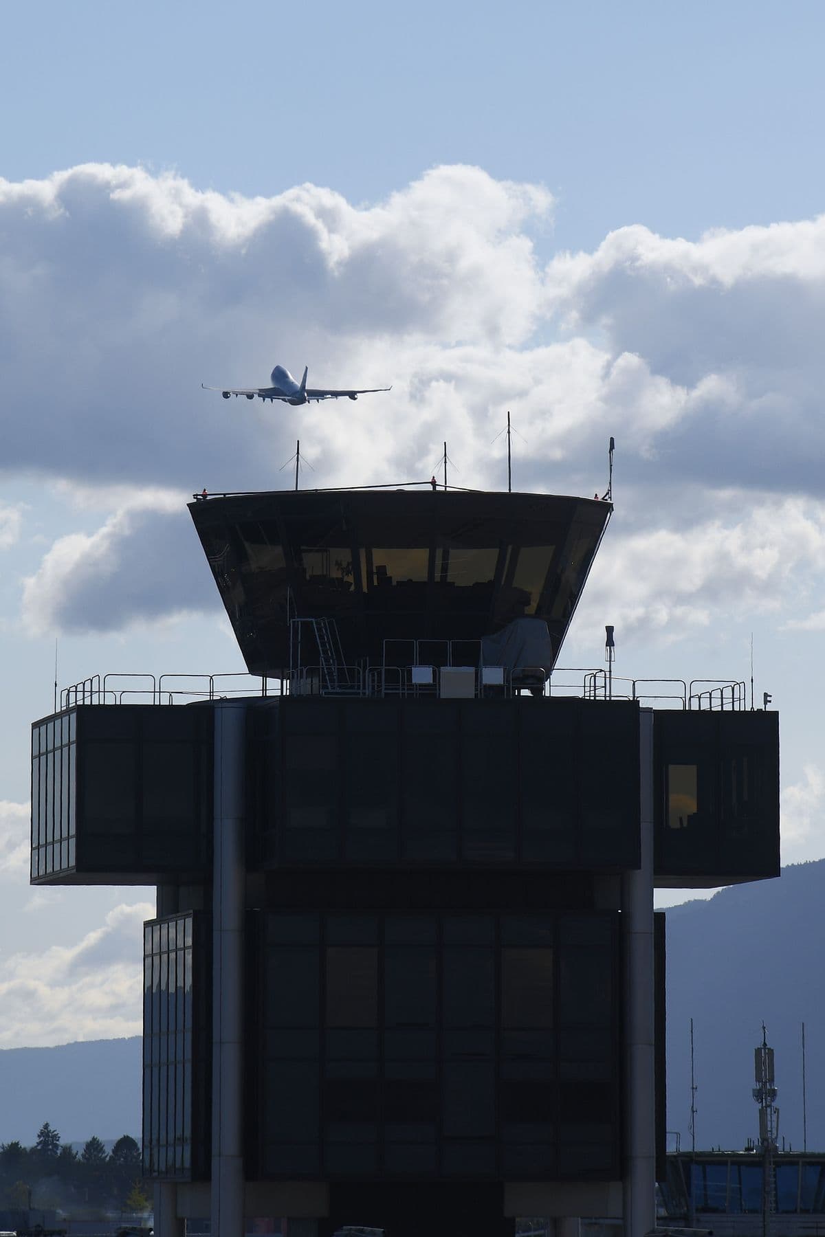 Avión despegando sobre la torre de control de un aeropuerto