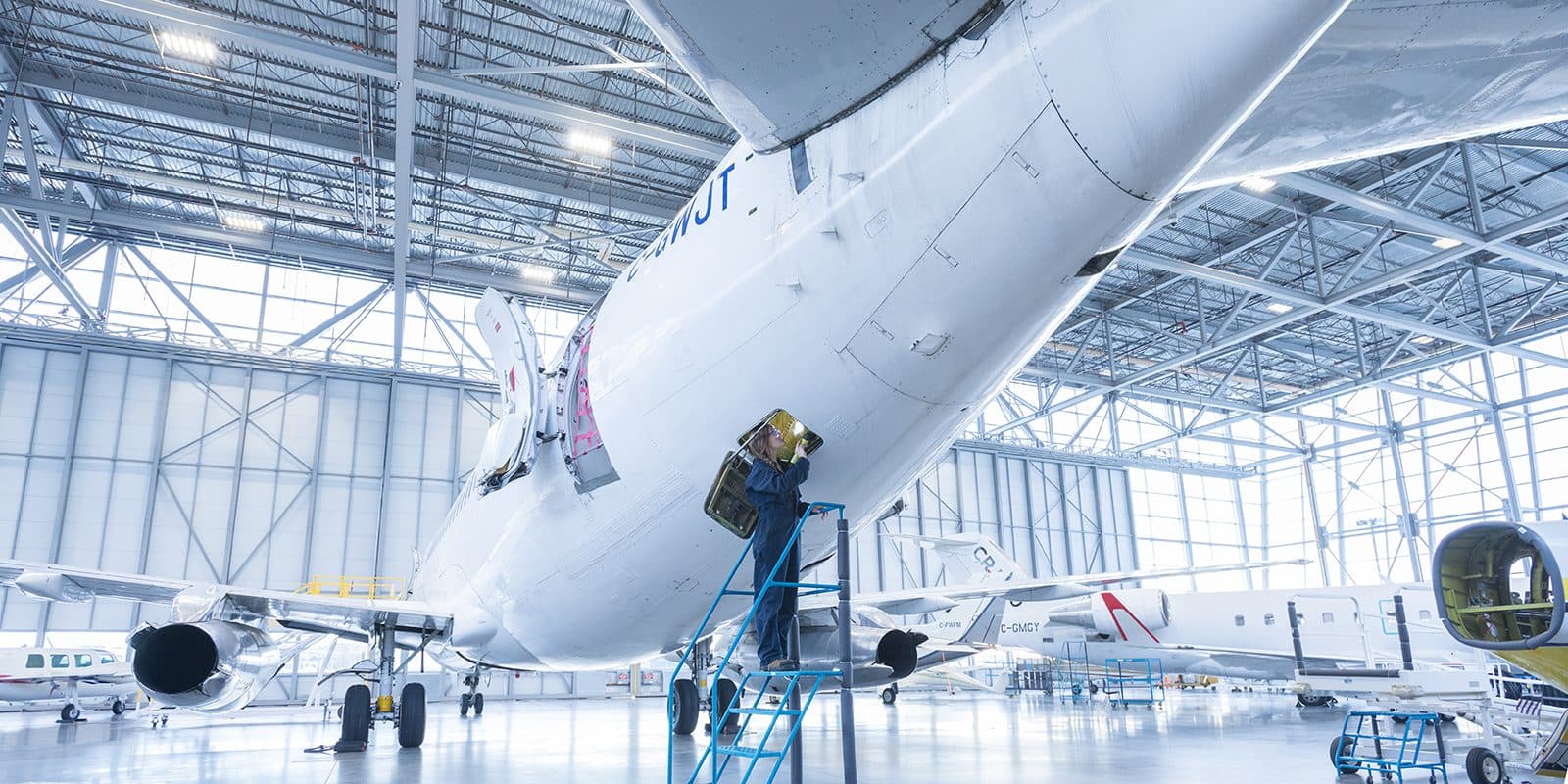 Estudiante de BCIT revisando un panel de aviónica en el fuselaje de un jet