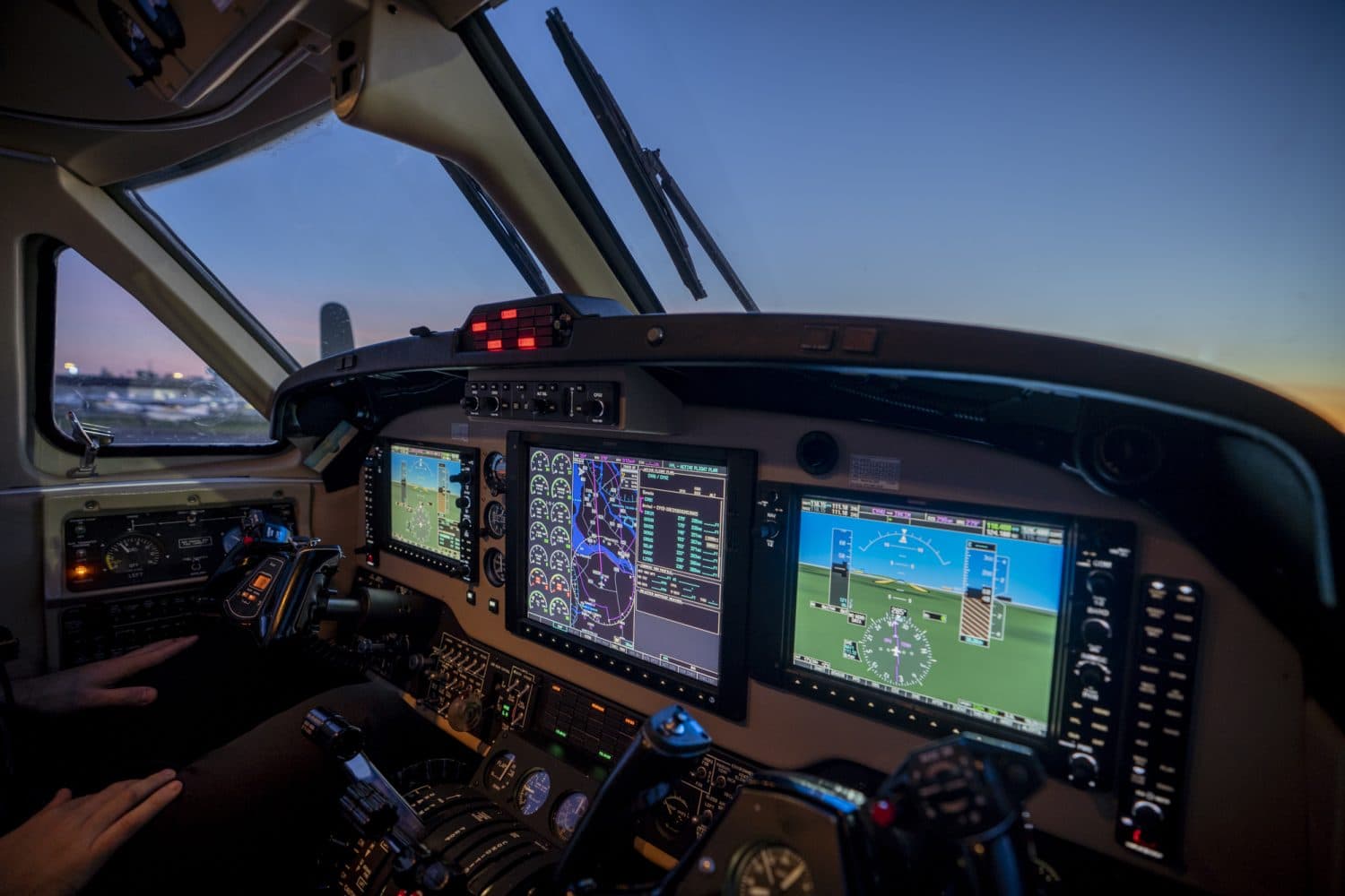 Cabina de una aeronave con instrumentos de vuelo iluminados al atardecer, programa Integrated ATP(A) de Cargair