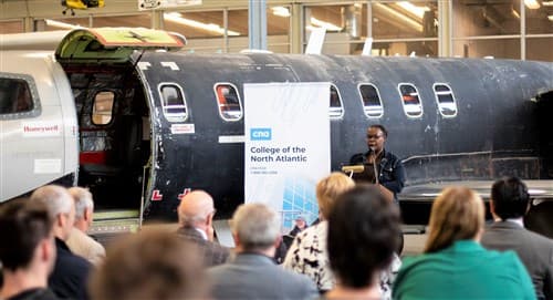 Evento en el hangar de aviación de College of the North Atlantic, con un fuselaje de aeronave de fondo