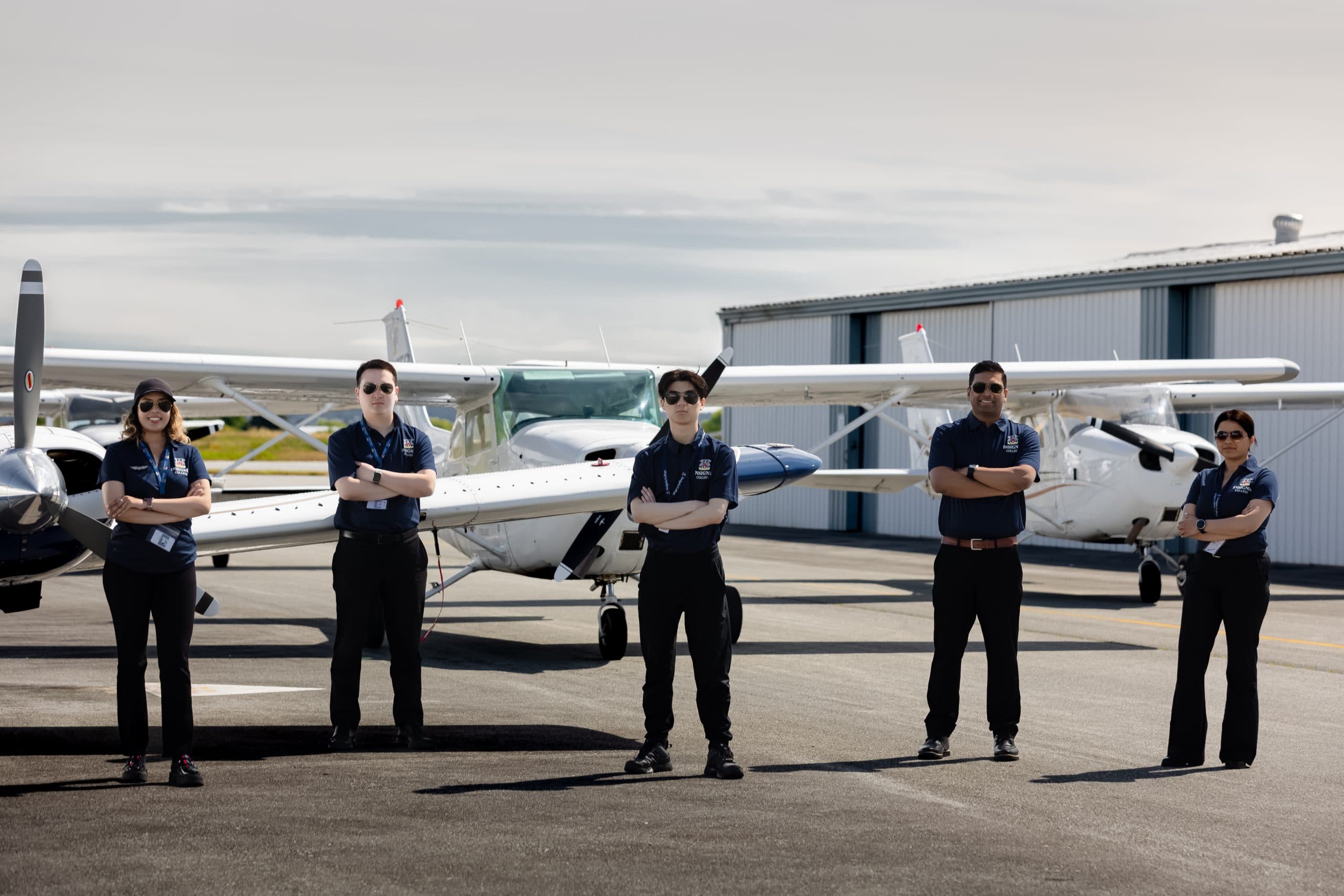 Equipo de Insignia College junto a una aeronave multimotor en Boundary Bay