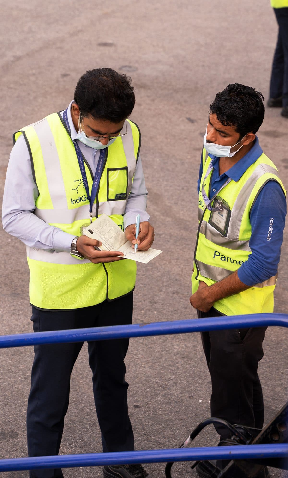 Personal de aeropuerto en chalecos de seguridad revisando documentos