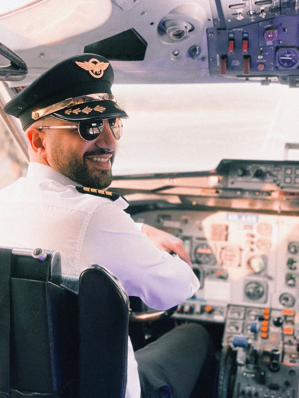 Piloto sonriendo en la cabina de un avión comercial
